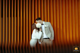 Hotel Wave, Międzyzdroje, Poland. Newlyweds pose for a post-ceremony photo session. The bride and groom are pictured against a distinctive hotel wall, partially mirrored in the frame.